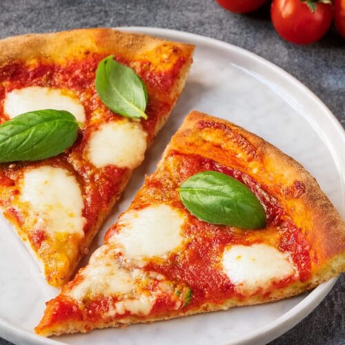 Classic Margherita Pizza, featuring a thin, crispy crust topped with fresh tomatoes, creamy mozzarella cheese, and aromatic basil leaves. This simple yet flavorful pizza highlights the perfect balance of tangy tomato sauce, rich cheese, and fragrant basil, making it a timeless favorite. Ideal for a quick weeknight dinner or a casual gathering, this Margherita Pizza offers a delicious taste of Italy in every slice.