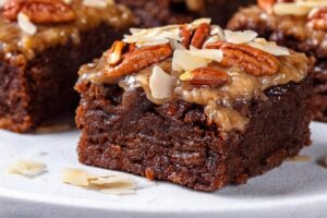 Rich and fudgy Chocolate Brownies with a delightful topping of toasted coconut and crunchy pecans. The combination of deep chocolate flavor, sweet coconut, and nutty pecans creates an irresistible texture and taste in every bite. Perfect for dessert or a sweet snack, these brownies are a delicious treat for any occasion.