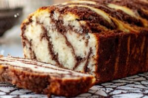 Indulge in the best of both worlds with our Chocolate Marble Cake, a delightful combination of rich chocolate and tender vanilla flavors swirled together in every slice. Picture a moist and fluffy vanilla cake batter, perfectly blended with rich chocolate batter to create a mesmerizing marble pattern throughout. Each bite offers a symphony of textures and tastes, with the sweetness of the vanilla balancing the deep richness of the chocolate. Whether enjoyed as a simple snack or dressed up with a dusting of powdered sugar or a drizzle of chocolate glaze, our Chocolate Marble Cake is a timeless classic that's sure to please any palate.