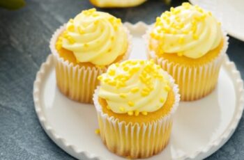 Freshly baked lemon cupcakes topped with a swirl of tangy lemon frosting. Each moist and airy cupcake embodies a burst of citrus, carrying the invigorating scent of lemon zest. Adorned with a vibrant yellow frosting that complements the light, fluffy texture of the cake, these treats are a delightful balance of sweet and tangy. The delicate, decorative lemon zest on top adds a visual charm, promising a delightful zing with every bite.
