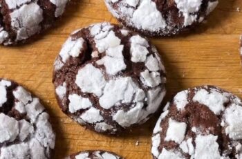 Decadent chocolate crinkle cookies that are a visual delight and a chocolate lover's dream. These cookies feature a rich cocoa dough, rolled in powdered sugar before baking, creating a crackled surface that reveals the contrasting dark chocolate beneath. The texture is a perfect balance between a crisp exterior and a fudgy, chewy interior. The aroma is an enticing mix of deep chocolate and a hint of vanilla. These cookies are not just a treat for the taste buds; their powdered sugar coating gives them a snow-dusted appearance, making them a charming addition to holiday cookie platters. With their distinctive appearance and intense chocolate flavor, chocolate crinkle cookies are sure to be a crowd-pleaser, perfect for festive occasions or simply satisfying your chocolate cravings.