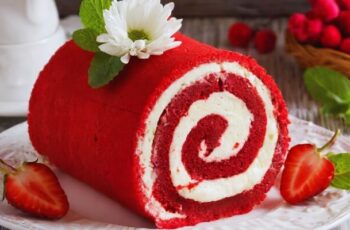 A stunning red velvet cake roll that combines the luxurious flavors of cocoa and a hint of buttermilk, creating a vibrant and visually striking dessert. The cake, with its deep red hue, is rolled around a luscious cream cheese filling, offering a perfect balance of sweetness and tang. The exterior is velvety soft, and each slice reveals a spiral of moist red velvet cake, adorned with a creamy white filling. A dusting of powdered sugar or a drizzle of white chocolate ganache adds an elegant finishing touch. This red velvet cake roll not only captivates the eyes but also delivers a delectable taste experience, making it a sophisticated and delightful addition to any special occasion or dessert table.