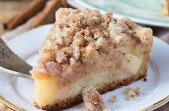 A mouthwatering Cinnamon Apple Crumb Cake that combines the warmth of cinnamon, the sweetness of apples, and the delightful texture of a crumb topping. This cake is a delicious treat for any occasion. The cake itself is typically infused with ground cinnamon and filled with chunks of fresh apples, creating a moist and flavorful base. The crumb topping is made with a mixture of flour, sugar, butter, and more cinnamon, offering a sweet and crumbly texture that complements the softness of the cake. Once baked to perfection, this crumb cake is often finished with a dusting of powdered sugar or a drizzle of vanilla glaze for an extra touch of sweetness and visual appeal. Whether enjoyed with a cup of coffee as a morning treat or served as a dessert after a cozy dinner, Cinnamon Apple Crumb Cake is a delightful way to savor the flavors of fall.