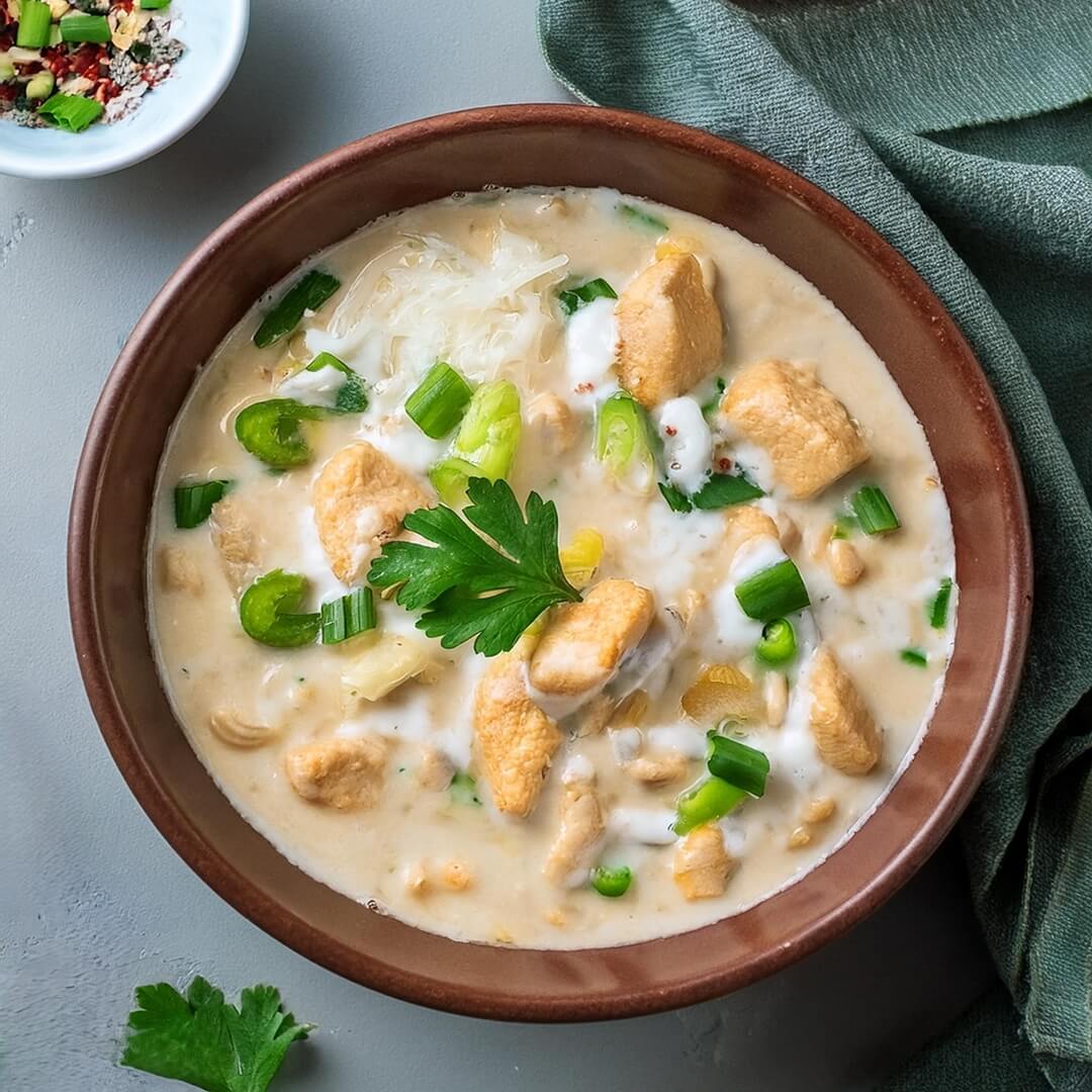 Rich and comforting Creamy White Chicken Chili made with tender shredded chicken, white beans, and green chilies in a smooth, creamy broth. This flavorful chili is seasoned with cumin, garlic, and onion, offering a hearty blend of spices and textures. Topped with sour cream, shredded cheese, and fresh cilantro, this easy-to-make dish is perfect for a cozy dinner or a satisfying meal on a chilly day.