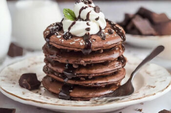 Indulge in the irresistible delight of double chocolate pancakes – a stack of fluffy, cocoa-infused pancakes generously drizzled with velvety chocolate sauce and topped with a decadent sprinkle of chocolate shavings. Each bite promises a perfect harmony of rich, moist cocoa goodness and the comforting warmth of freshly made pancakes. Whether you're a chocolate lover or a brunch enthusiast, these double chocolate pancakes are a heavenly treat that will satisfy your sweet cravings.