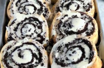 Delicious Oreo Cinnamon Rolls that put a delightful twist on the classic cinnamon roll by incorporating the iconic flavor of Oreo cookies. These rolls are perfect for those who enjoy a combination of chocolatey goodness and the warm, comforting aroma of cinnamon rolls. The cinnamon roll dough is typically made with flour, sugar, yeast, milk, and butter. Crushed Oreo cookies or Oreo cookie crumbs are incorporated into the dough, infusing it with that distinctive Oreo flavor. The dough is rolled out and generously spread with a mixture of cinnamon, sugar, and sometimes additional crushed Oreos. Once rolled and sliced, the Oreo cinnamon rolls are baked to a golden perfection. They can be topped with a cream cheese frosting that may also include a hint of Oreo crumbs, adding extra richness and flavor. These Oreo Cinnamon Rolls offer a delightful and unexpected twist that's sure to please any Oreo cookie enthusiast, making them a fun and indulgent treat for breakfast or brunch.