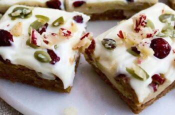 A homemade version of Starbucks Cranberry Bliss Bars, capturing the irresistible flavors of these iconic treats. These bars are a delightful blend of sweet, tart, and creamy, making them a perfect addition to your dessert repertoire. The base layer typically consists of a blondie or cookie-like batter, flavored with vanilla and studded with white chocolate chips and dried cranberries. Once baked to a golden perfection, the bars are topped with a cream cheese frosting infused with orange zest, offering a tangy and citrusy contrast. To complete the signature look, a drizzle of white chocolate over the frosting adds a finishing touch, providing both visual appeal and an extra layer of sweetness. Whether enjoyed with a cup of coffee or as a festive dessert during the holiday season, these homemade Cranberry Bliss Bars are a delightful way to recreate the flavors of the popular Starbucks treat in the comfort of your own kitchen.