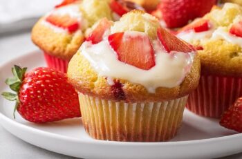 Strawberry Cream Cheese Muffins feature moist, fluffy batter filled with juicy strawberries and a creamy, tangy cream cheese center. A golden streusel crumb topping adds crunch, while a drizzle of sweet glaze completes these irresistible treats—perfect for breakfast or dessert!