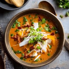 Rich and hearty Chicken Enchilada Soup featuring tender shredded chicken, black beans, corn, and a bold enchilada sauce simmered in a flavorful broth. This easy-to-make soup is packed with Mexican-inspired spices, offering a delicious combination of heat and comfort. Topped with shredded cheese, tortilla strips, and fresh cilantro, it's a perfect choice for a cozy dinner or a satisfying lunch.