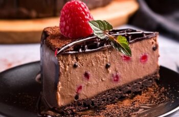 Indulge in the luxurious decadence of our Raspberry Chocolate Cheesecake. Picture a rich and creamy chocolate cheesecake, perfectly baked atop a crunchy chocolate cookie crust. Each slice reveals swirls of vibrant raspberry puree, creating a harmonious blend of tart and sweet flavors. The cheesecake is elegantly finished with a glossy chocolate ganache and adorned with fresh raspberries, adding a burst of color and freshness. Perfect for any celebration or simply treating yourself, this Raspberry Chocolate Cheesecake is a gourmet delight that promises an unforgettable dessert experience.