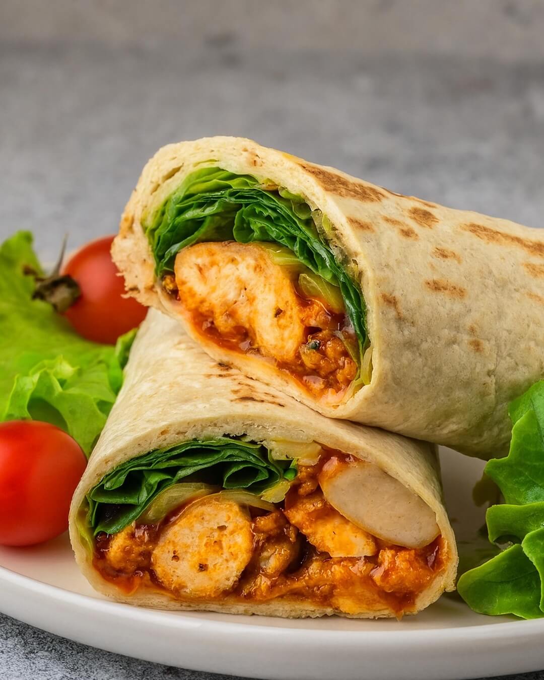 The popular Buffalo Chicken Wrap features tender buffalo chicken on a bed of crisp vegetables, topped with cheese and creamy dressing, all wrapped snugly in a tasty flour tortilla.