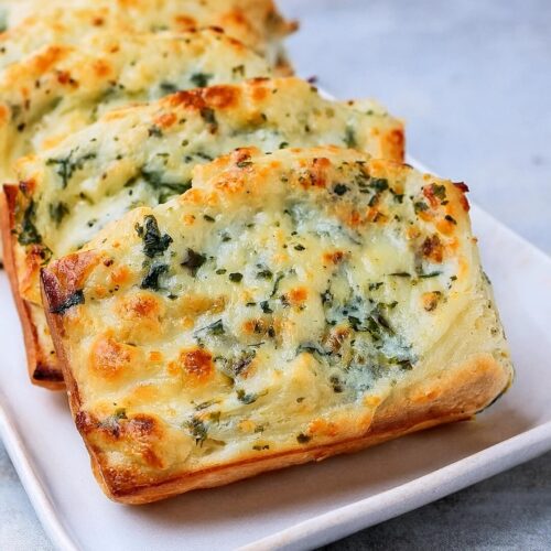 warm, crusty bread topped with a creamy, cheesy spinach and artichoke mixture, baked to golden perfection. This dish combines the best of both worlds – the irresistible flavors of spinach artichoke dip and the comforting crunch of fresh bread. It’s a guaranteed hit for parties, game nights, or simply as a delightful snack.