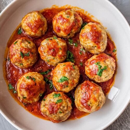Chicken Meatballs are tender and seasoned with classic Italian herbs and spices, while spinach adds a fresh touch. When served with tomato sauce, these meatballs become a perfect comfort food addition to pasta, sub sandwiches, or as a main dish.