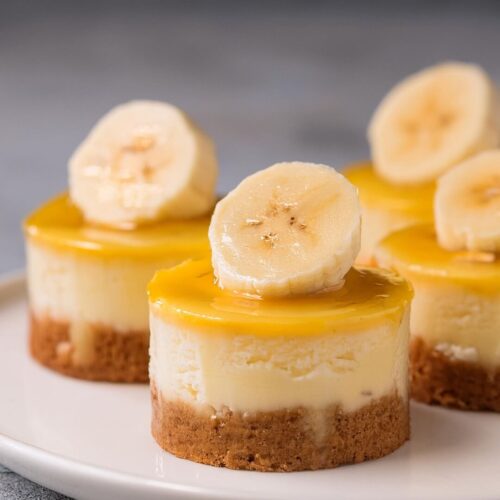 These Mini Banana Pudding Cheesecakes are the perfect blend of creamy cheesecake and classic banana pudding, all in a bite-sized treat! Each mini cheesecake features a buttery graham cracker crust, a smooth banana-flavored cheesecake filling. Topped with fresh banana slices and a vanilla wafer for that nostalgic touch, these little cheesecakes are a delightful mix of flavors and textures. Whether for a party or a personal indulgence, these mini treats are sure to satisfy your sweet tooth.