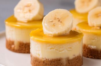 These Mini Banana Pudding Cheesecakes are the perfect blend of creamy cheesecake and classic banana pudding, all in a bite-sized treat! Each mini cheesecake features a buttery graham cracker crust, a smooth banana-flavored cheesecake filling. Topped with fresh banana slices and a vanilla wafer for that nostalgic touch, these little cheesecakes are a delightful mix of flavors and textures. Whether for a party or a personal indulgence, these mini treats are sure to satisfy your sweet tooth.