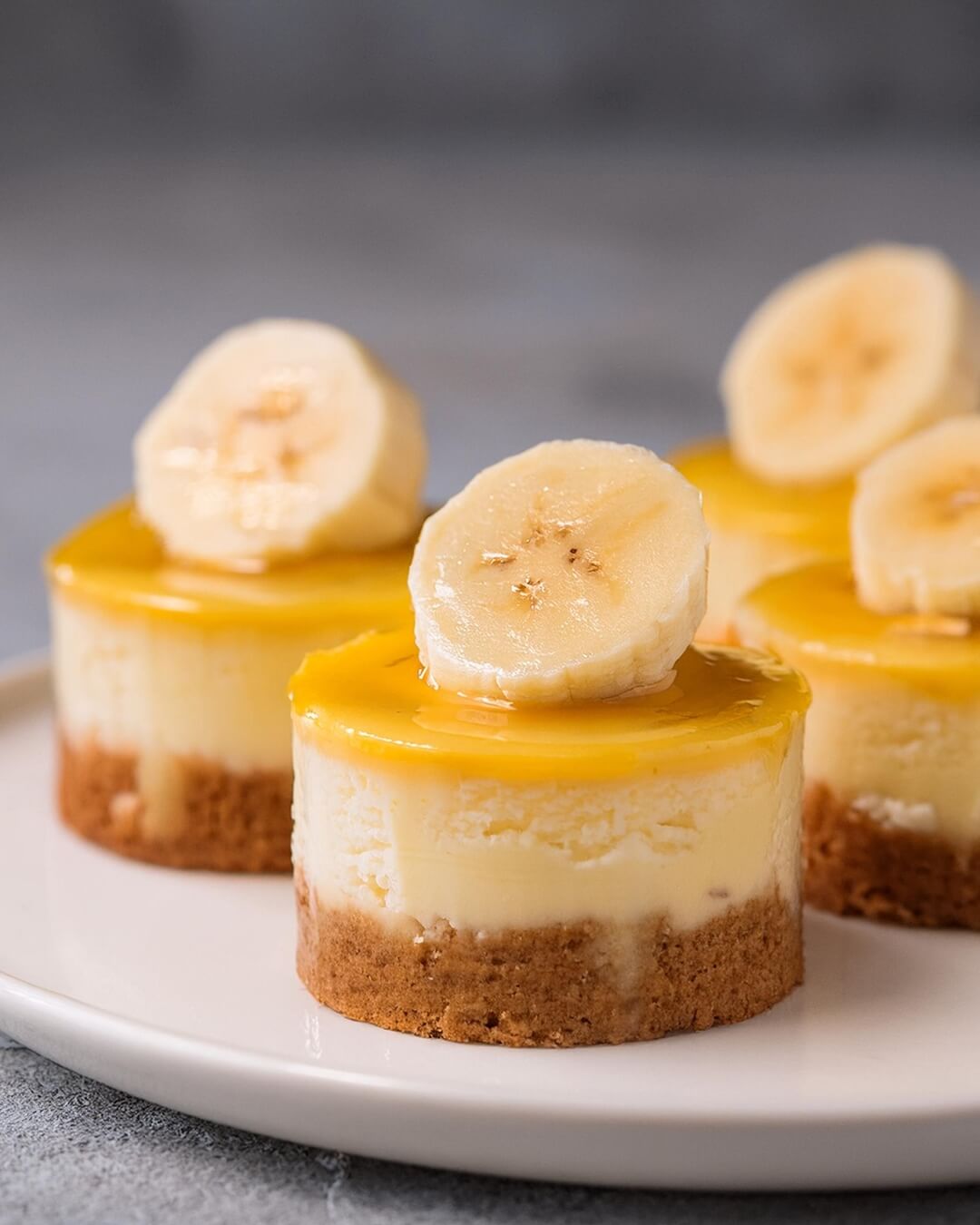 These Mini Banana Pudding Cheesecakes are the perfect blend of creamy cheesecake and classic banana pudding, all in a bite-sized treat! Each mini cheesecake features a buttery graham cracker crust, a smooth banana-flavored cheesecake filling. Topped with fresh banana slices and a vanilla wafer for that nostalgic touch, these little cheesecakes are a delightful mix of flavors and textures. Whether for a party or a personal indulgence, these mini treats are sure to satisfy your sweet tooth.