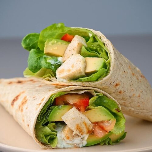 The Avocado Chicken Caesar Wrap combines tender grilled chicken, crisp romaine lettuce, creamy avocado, sweet grape tomatoes, and sharp parmesan cheese, all wrapped in a soft tortilla. It’s complemented by a homemade Caesar dressing made with Greek yogurt, mayo, anchovies, and tangy lemon, delivering a healthier, flavorful twist on the classic Caesar. Perfect for a light yet satisfying meal.