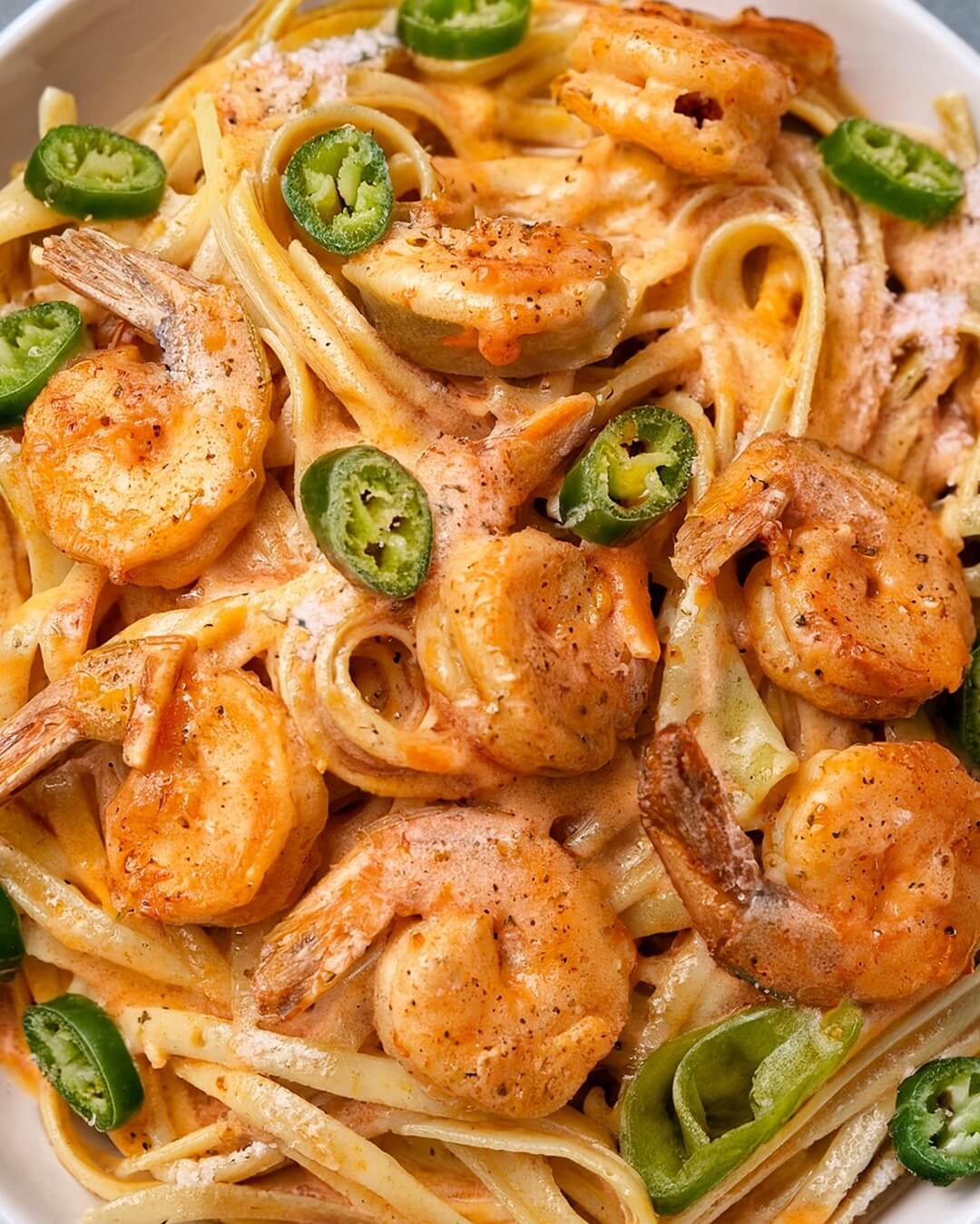 Cajun Prawn Pasta combines tender, spiced prawns with a creamy Cajun sauce packed with bold flavors from hot sauce, Worcestershire, and a touch of vinegar. Sweet bell pepper, spicy jalapeño, and garlic provide balance and depth, while parmesan adds richness. Served over linguine and garnished with fresh parsley, this dish is a spicy, creamy delight perfect for any pasta lover.