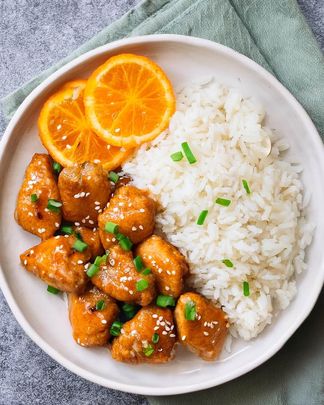 The Lighter Orange Chicken features tender, diced chicken breasts sautéed in a light canola oil, then coated in a sweet and tangy orange sauce made with fresh orange juice, honey, soy sauce, and a touch of Sriracha for heat. The sauce is thickened with cornstarch for a glossy finish and served with a sprinkle of green onions and sesame seeds for extra texture and flavor. It’s a healthier take on a classic dish, with all the citrusy sweetness and savory depth you crave!