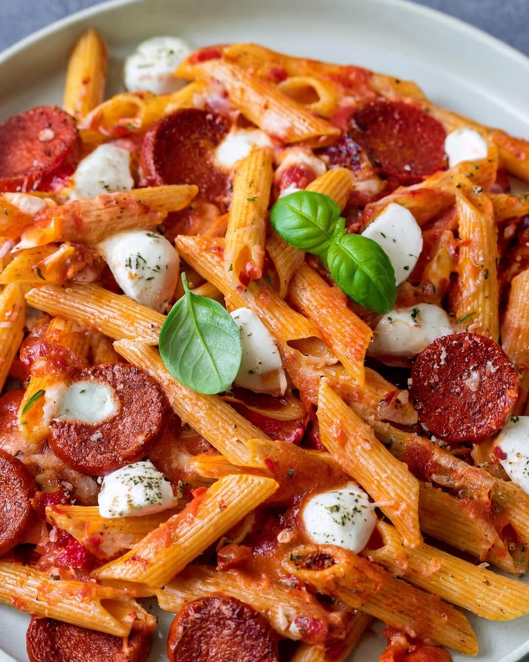 Penne Arrabbiata with chorizo combines the heat of chili flakes and the smokiness of chorizo with a rich tomato sauce. Red and yellow bell peppers, along with onion and garlic, enhance the sauce's flavor, while mozzarella provides a creamy contrast to the spice. This dish is a comforting blend of bold, spicy flavors with a savory, slightly sweet undertone.