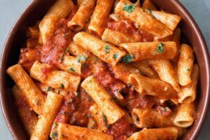 Sausage Rigatoni features rigatoni pasta tossed in a creamy tomato sauce made with Italian sausage, garlic, onions, and both diced and crushed tomatoes. The richness of the sausage is balanced with the tanginess of the tomatoes and the smooth creaminess of heavy cream. Fresh basil and grated Parmesan finish the dish, adding fresh and savory notes for the perfect comforting meal.