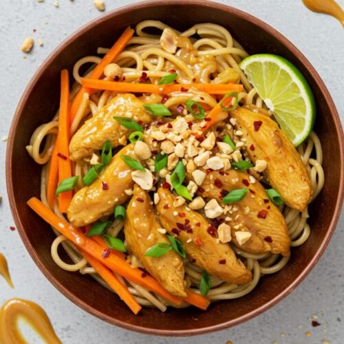 Spicy Peanut Chicken Noodles combines rice noodles and a spicy, creamy peanut sauce with tender ground chicken and fresh vegetables.