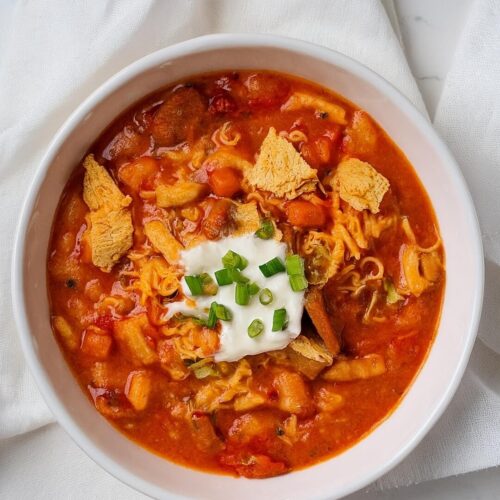 Buffalo Chicken Chili is a hearty, spicy dish that combines the zesty heat of Buffalo sauce with tender chicken, creamy beans, and smoky spices. Topped with blue cheese, tortilla chips, and fresh herbs, it's the ultimate comfort food with a fiery kick.