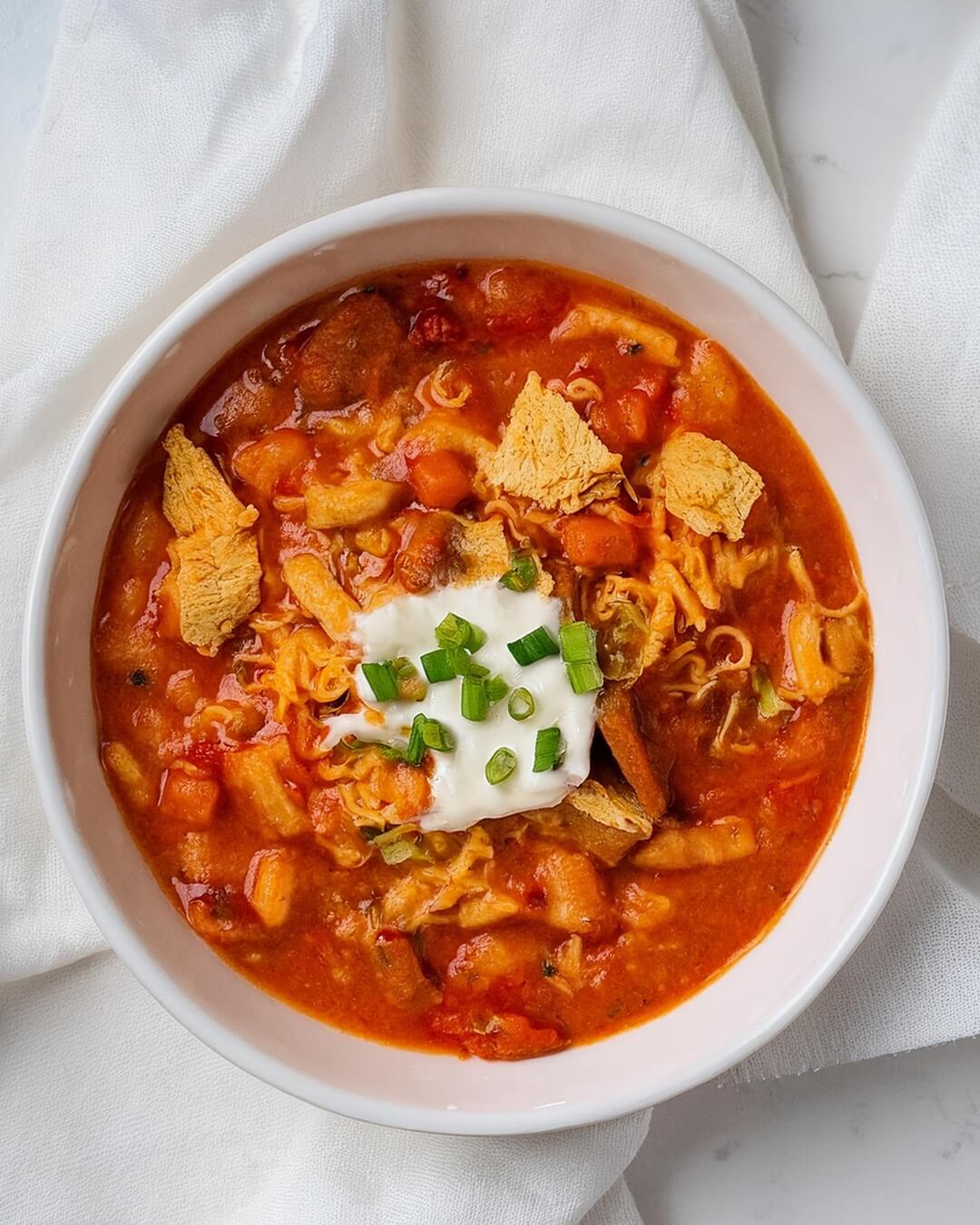 Buffalo Chicken Chili is a hearty, spicy dish that combines the zesty heat of Buffalo sauce with tender chicken, creamy beans, and smoky spices. Topped with blue cheese, tortilla chips, and fresh herbs, it's the ultimate comfort food with a fiery kick.