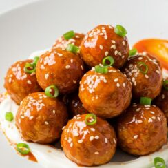 Firecracker Chicken Meatballs are a delicious and spicy appetizer that features tender chicken meatballs coated in a glossy, spicy sauce.