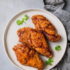 Crunchy Honey Buffalo Chicken features tender chicken coated in a crispy cornflake crust, seasoned with Parmesan and smoky spices. Drizzled with a sweet and spicy honey buffalo sauce, this dish offers a perfect balance of heat, sweetness, and crunch. Serve with ranch or blue cheese dressing and a sprinkle of green onions for an irresistible meal or appetizer!