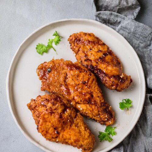 Crunchy Honey Buffalo Chicken features tender chicken coated in a crispy cornflake crust, seasoned with Parmesan and smoky spices. Drizzled with a sweet and spicy honey buffalo sauce, this dish offers a perfect balance of heat, sweetness, and crunch. Serve with ranch or blue cheese dressing and a sprinkle of green onions for an irresistible meal or appetizer!