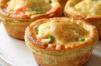 Cozy comfort in every bite! These Mini Chicken Pot Pies are packed with creamy chicken, veggies, and buttery biscuit dough for a satisfying meal that's as cute as it is delicious.