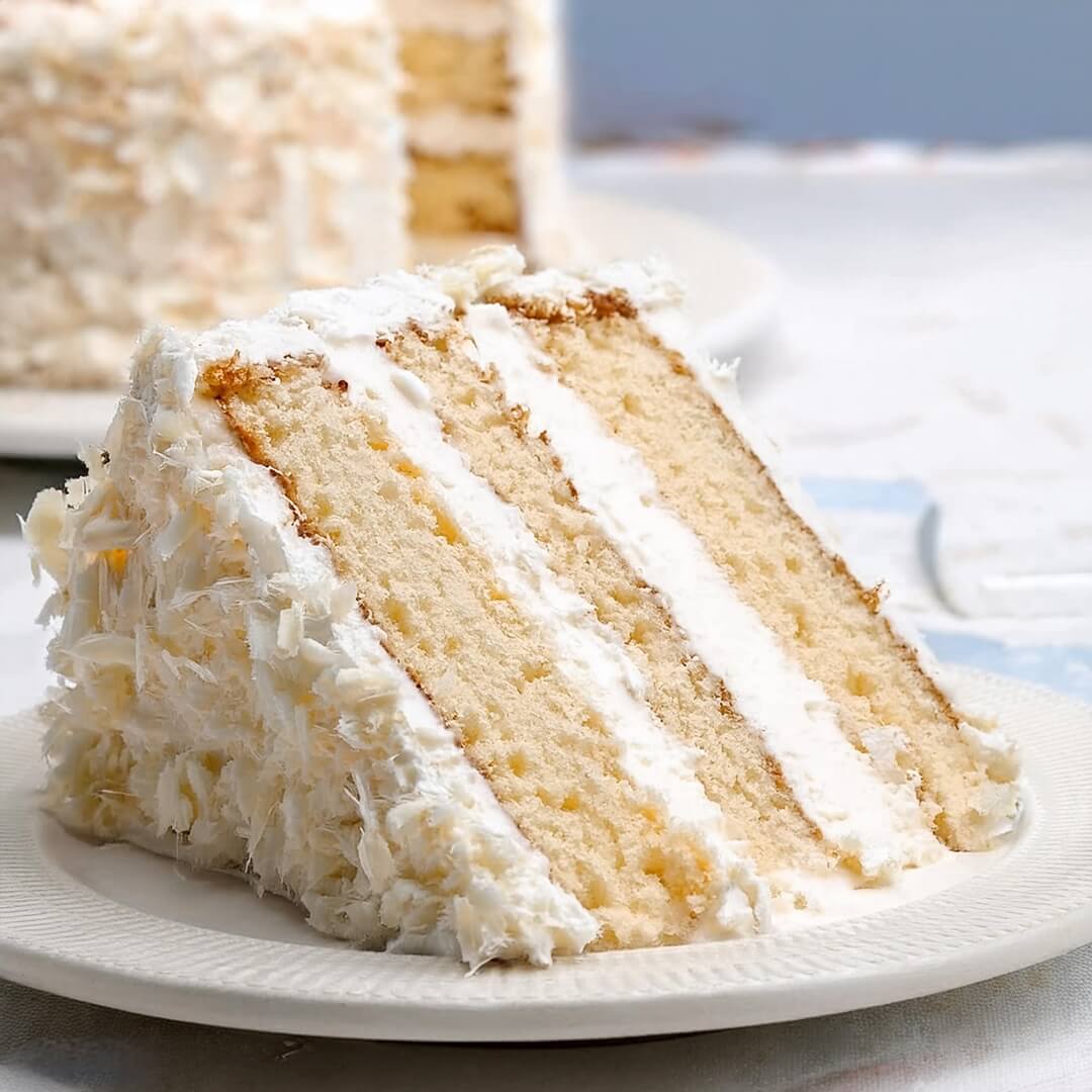 This Coconut Cake is soft, fluffy, and bursting with tropical flavor! Coconut milk, shredded coconut, and a creamy coconut buttercream make it irresistible