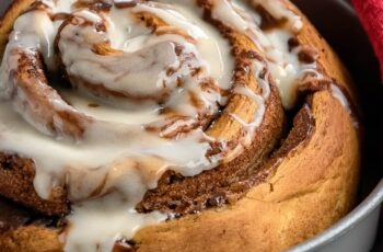 Giant Cinnamon Roll with Cream Cheese Frosting is the ultimate cozy indulgence—a supersized version of the classic breakfast favorite, swirled with cinnamon sugar and topped with rich, tangy cream cheese frosting. This stunning treat is soft, gooey, and perfect for sharing!