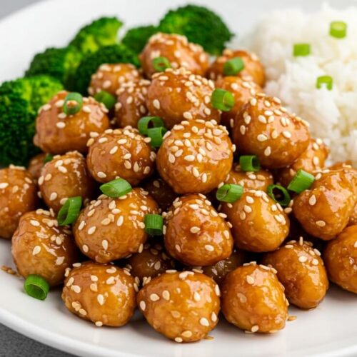 Crispy, juicy sesame chicken tossed in a sticky-sweet, garlicky sauce, served over fluffy jasmine rice and topped with scallions and sesame seeds